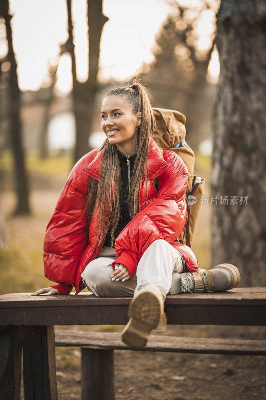 成功的女人徒步登山在日出的山顶-年轻的女人背包上升到山顶。发现旅游目的地