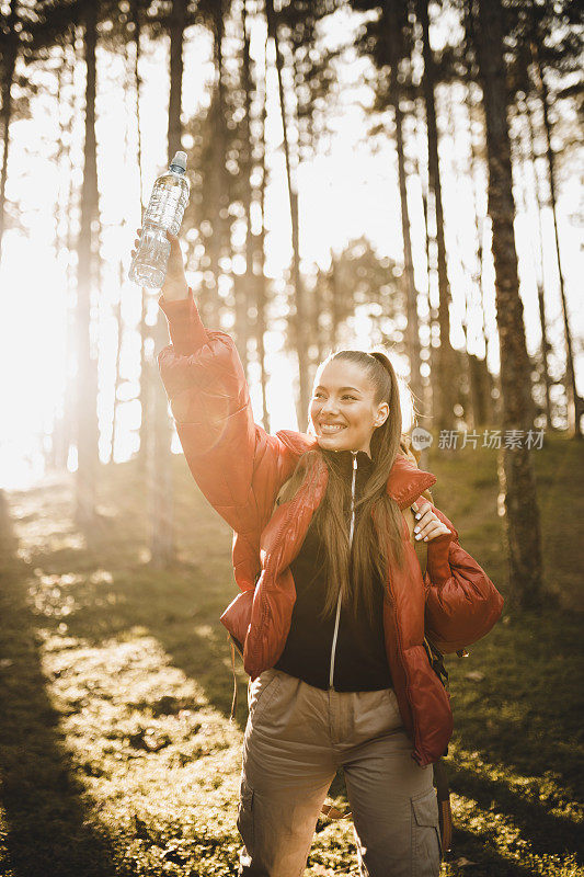 成功的女人徒步登山在日出的山顶-年轻的女人背包上升到山顶。发现旅游目的地