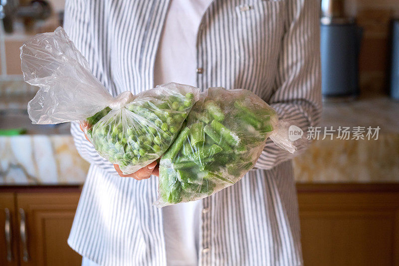 展示冷冻蔬菜食品的妇女