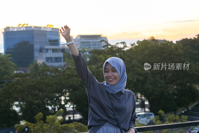 年轻女性戴着头巾在屋顶城市公园放松