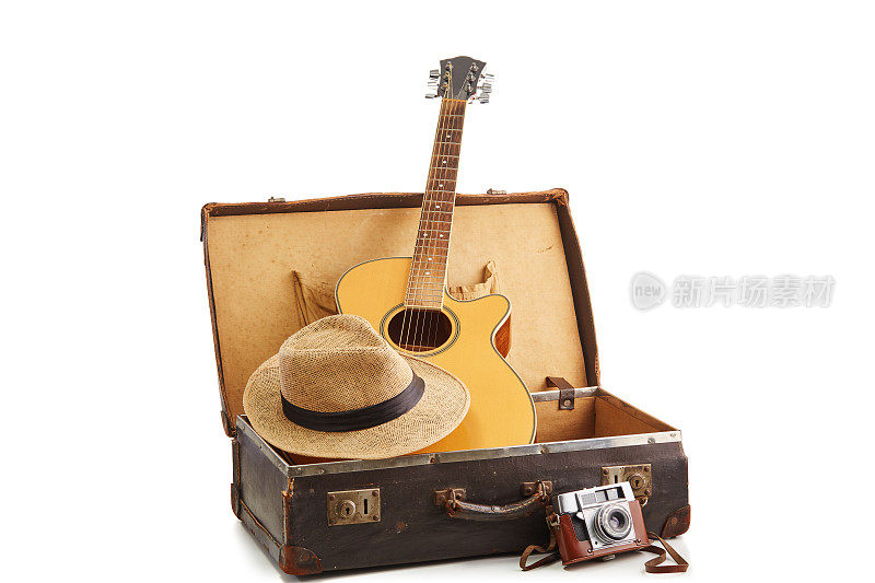 老式的老式棕色皮箱，白色上有吉他，电影相机和草帽。准备好旅行，度假和有趣的概念