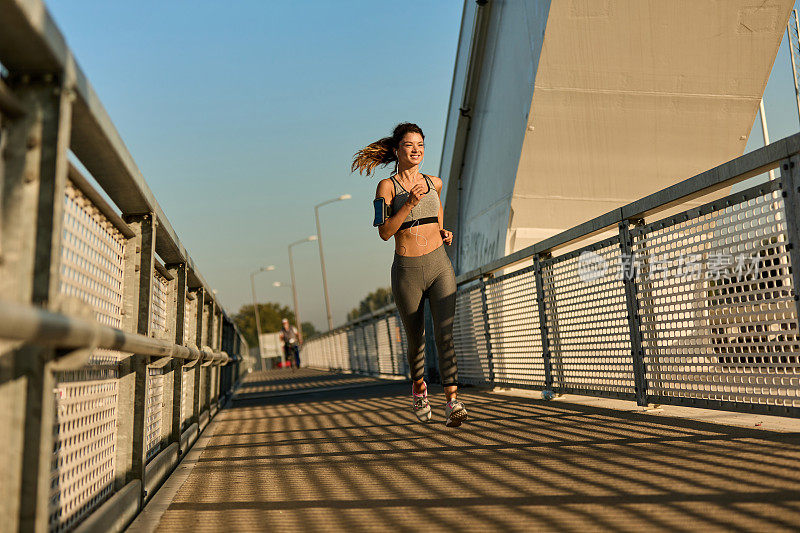 女慢跑者跑过桥