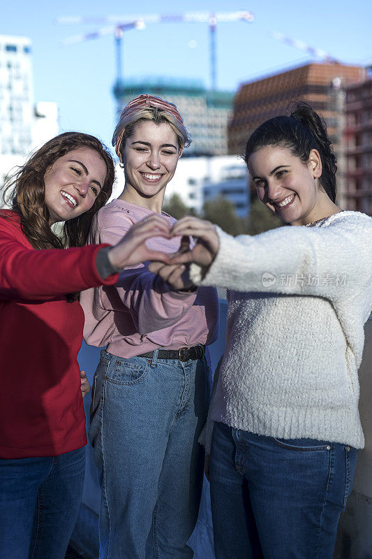 三位女性朋友用手做心形