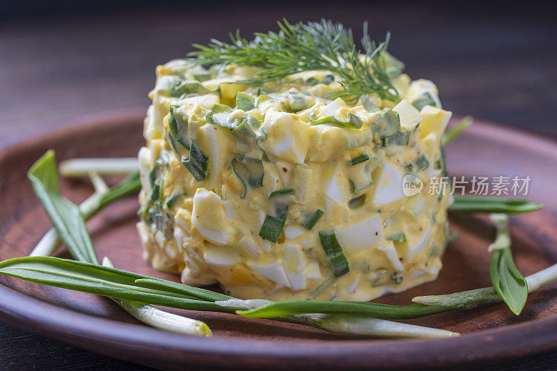 绿色韭葱，水煮蛋和酸奶油的健康沙拉。野蒜沙拉配煮蛋