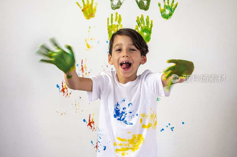 男孩在他的手上展示彩色颜料