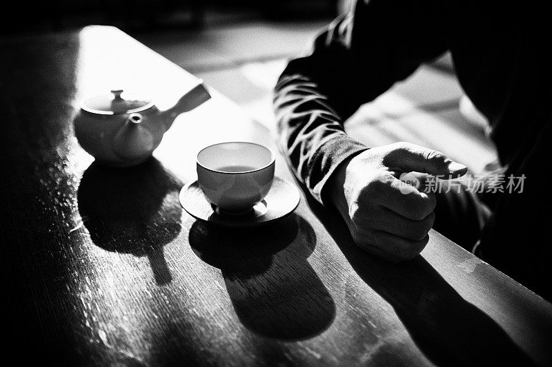 男人用日本茶壶和茶杯喝茶的画面