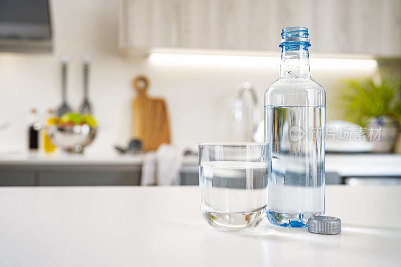厨房柜台上有玻璃和塑料水瓶