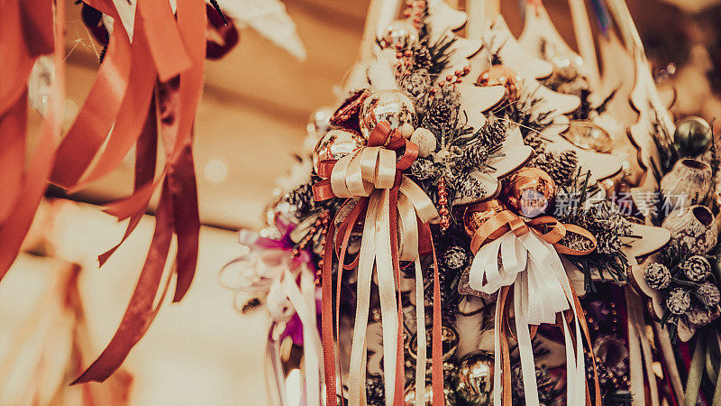 圣诞节的家庭装饰-在市场摊位上用小玩意儿、松果和缎带做成的树花环