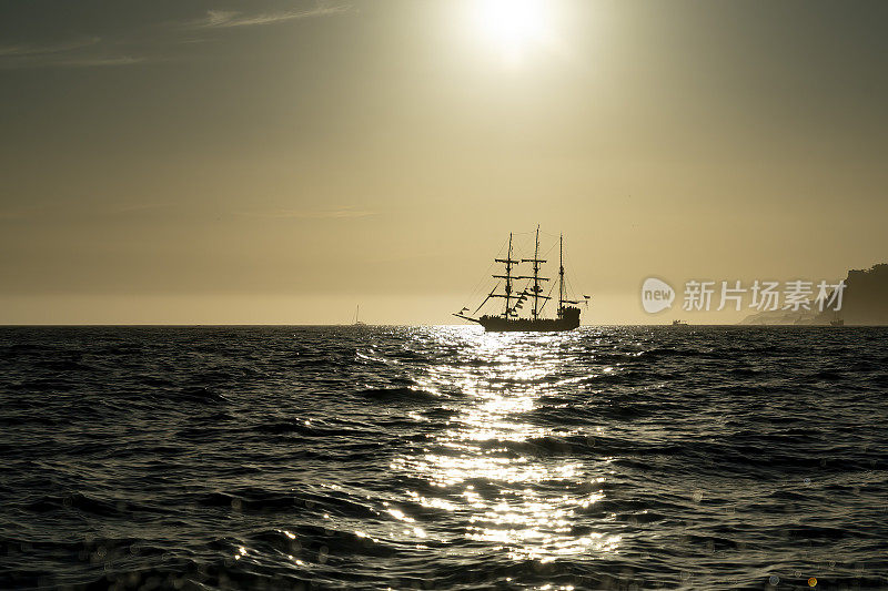 海盗船的剪影在日落时分的公海上