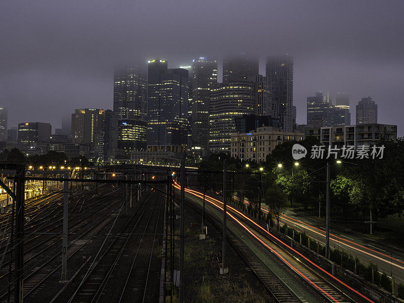 雾蒙蒙的早晨，城市天际线和火车轨道