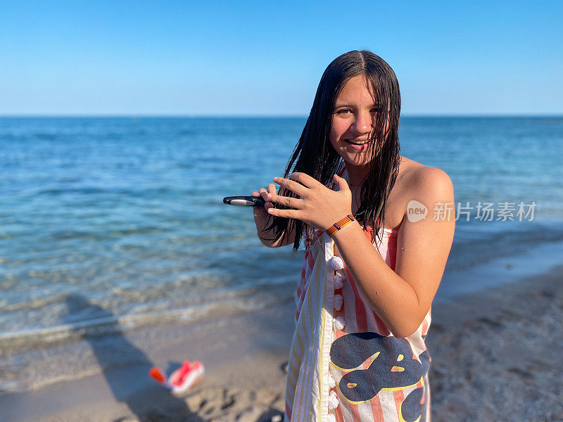 微笑的少女在沙滩上梳头