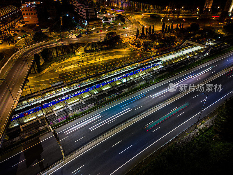 空中无人机的天空视图拍摄的交通在里斯本在夜间与五颜六色的光轨迹