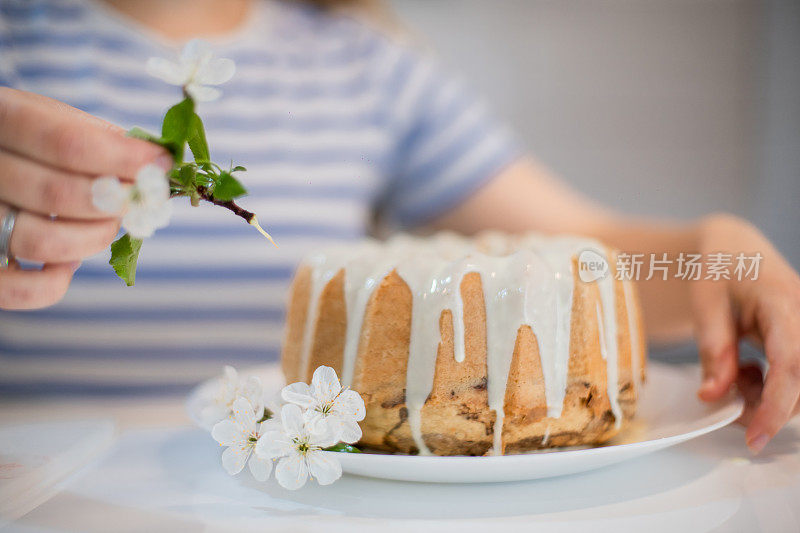 年轻女子用白色花朵装饰库格霍夫蛋糕