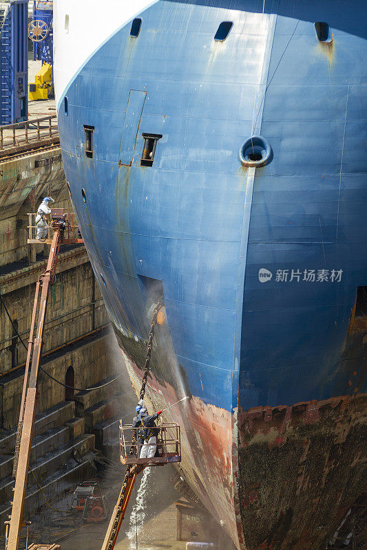 在直布罗陀的一个造船厂，工人们正在用压力喷砂技术清理商船船体上的杂质和油漆