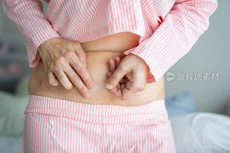 亚洲女人的腹部。使用激素替代贴片