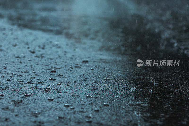 沥青路上的雨滴。天气。背景。雨