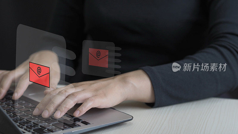 商务女性双手使用笔记本电脑在键盘上打字，在办公桌上上网，电子邮件图标，电子邮件营销概念，发送电子邮件或新闻信件，在线工作互联网网络，红色邮件图标。
