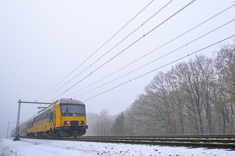 荷兰铁路公司的城际列车行驶在雪地上