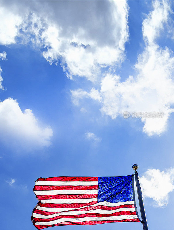 美国国旗插在旗杆上，天空晴朗湛蓝