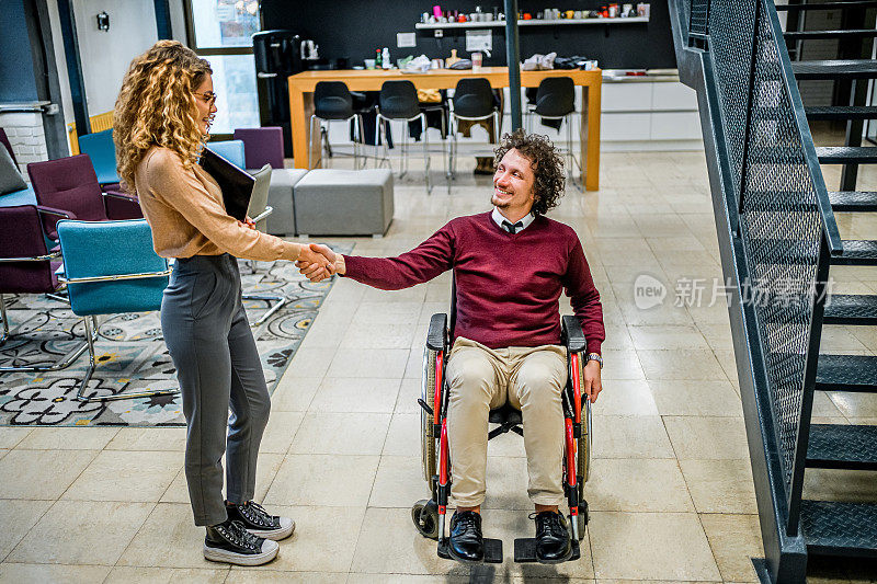 一位女士和她的残疾同事握手