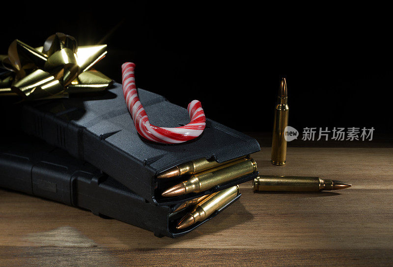 装满弹夹的AR-15弹匣和带金色圣诞蝴蝶结的拐杖糖