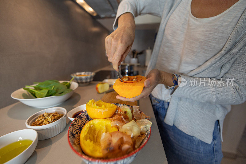 妇女在自家厨房做饭，减少了家里的食物浪费