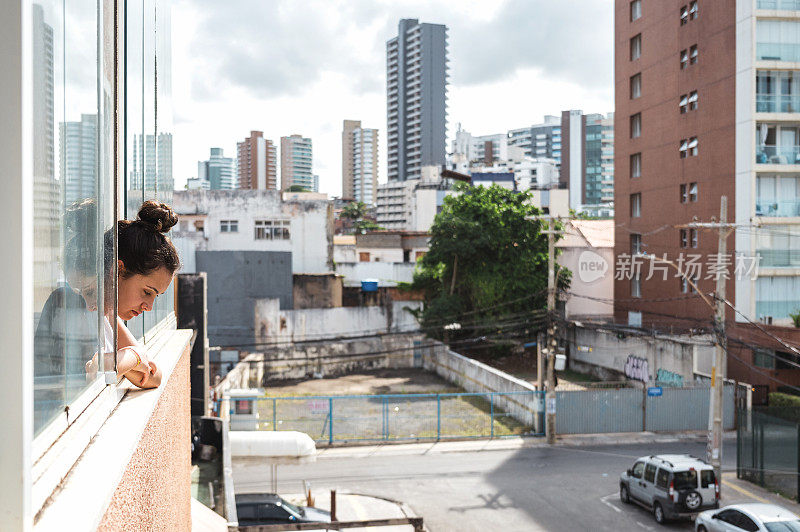 年轻女子望着窗外的城市