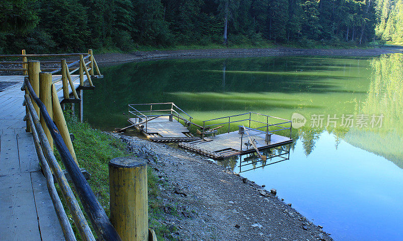 在一个美丽的森林湖的木泊位附近罕见的旧桨筏
