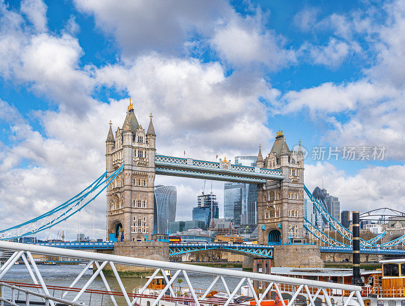 伦敦塔桥从泰晤士河上的轮渡码头出发，船舶交通沿着下游航行，道路交通和伦敦公共汽车在桥上行驶。