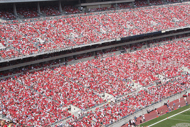 拥挤的足球场集中了穿红色衣服的人群