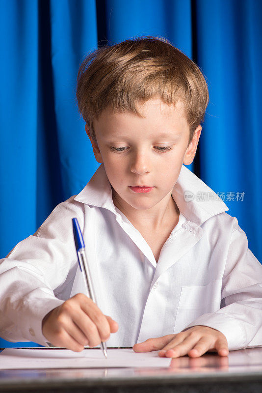 男孩在一张纸上写字