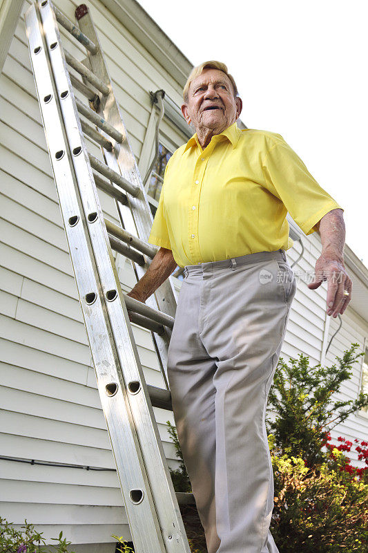 一位老人站在屋后的梯子上遥望远方