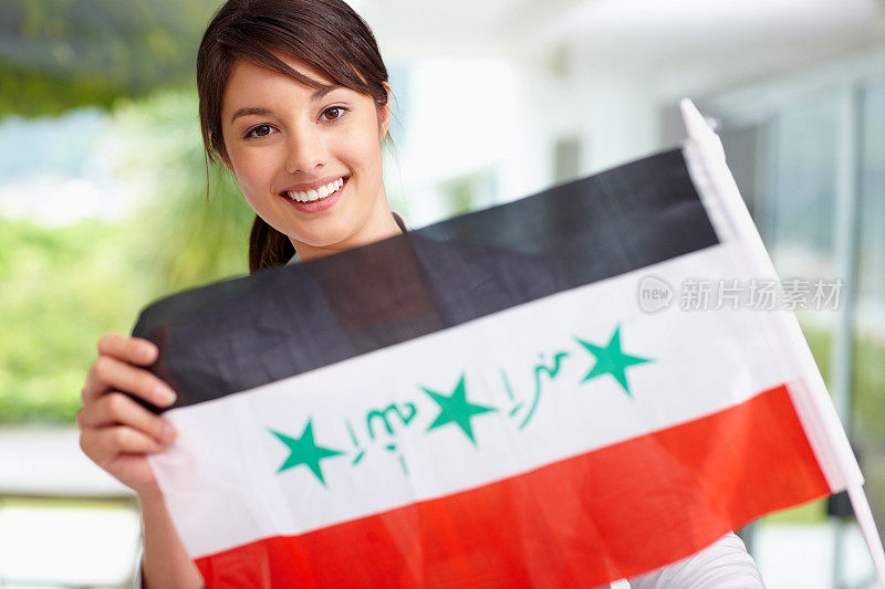 一位年轻漂亮的女性，她展示着伊拉克国旗