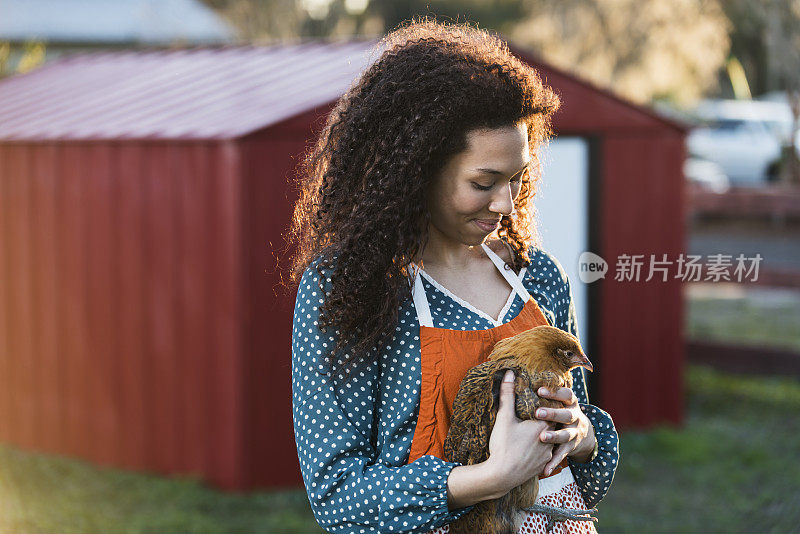 一个十几岁的女孩在农场养母鸡