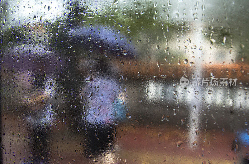 雨点落在窗户上，从车里看到行人