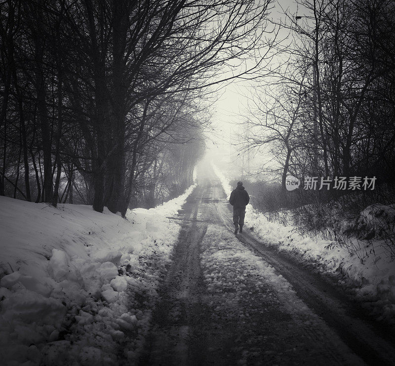 在雾和雪中行走的老人，乡村巷。