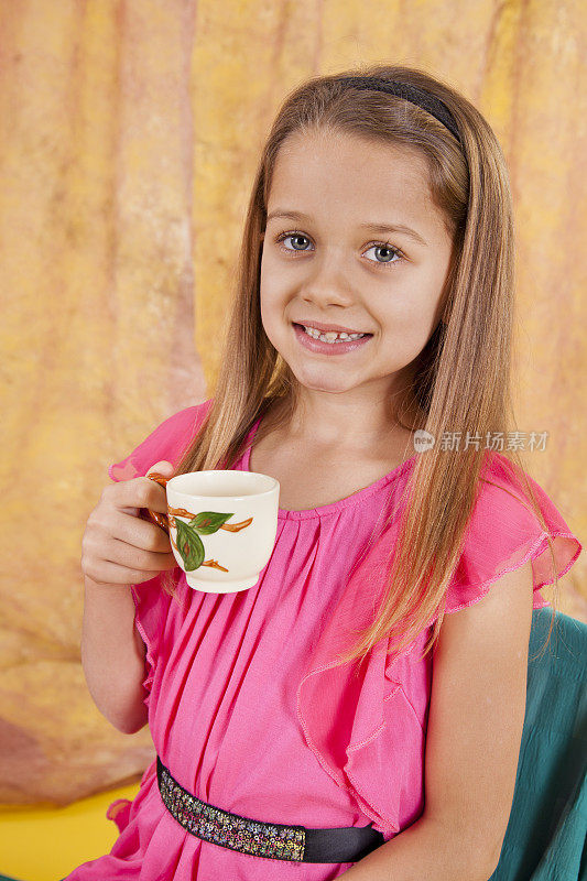 7尺8寸的白人女孩，微笑着拿着茶杯在茶会上玩