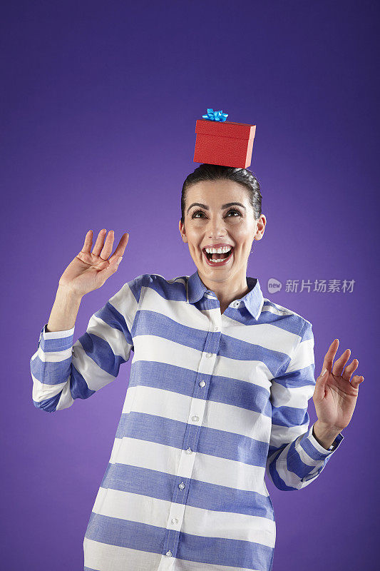 头上顶着一个红色礼品盒的女人