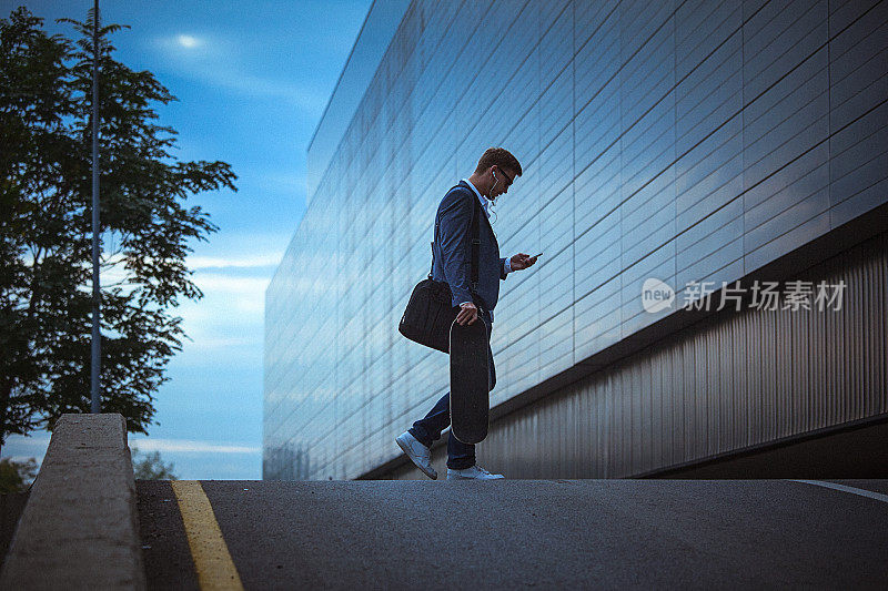 年轻的休闲商人在城市环境中使用智能手机