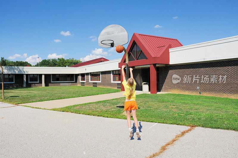 小女孩在小学操场上打篮球