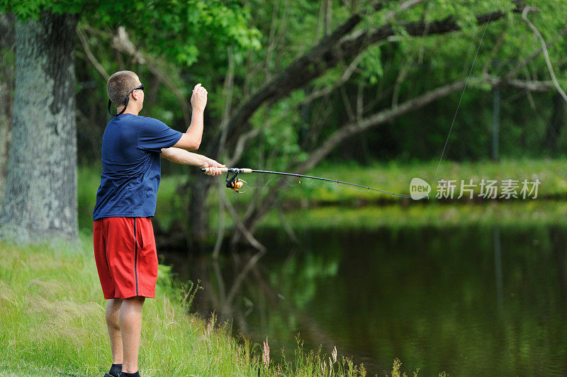 年轻人在湖边抛钓竿