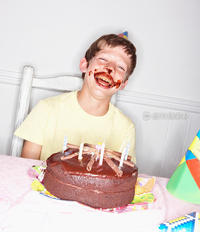 小男孩吃完生日蛋糕后笑了