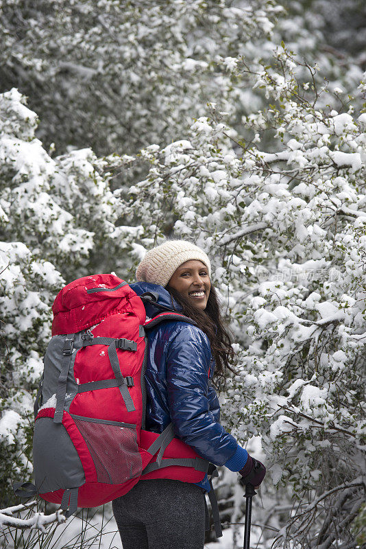 在雪道上徒步旅行的女人。