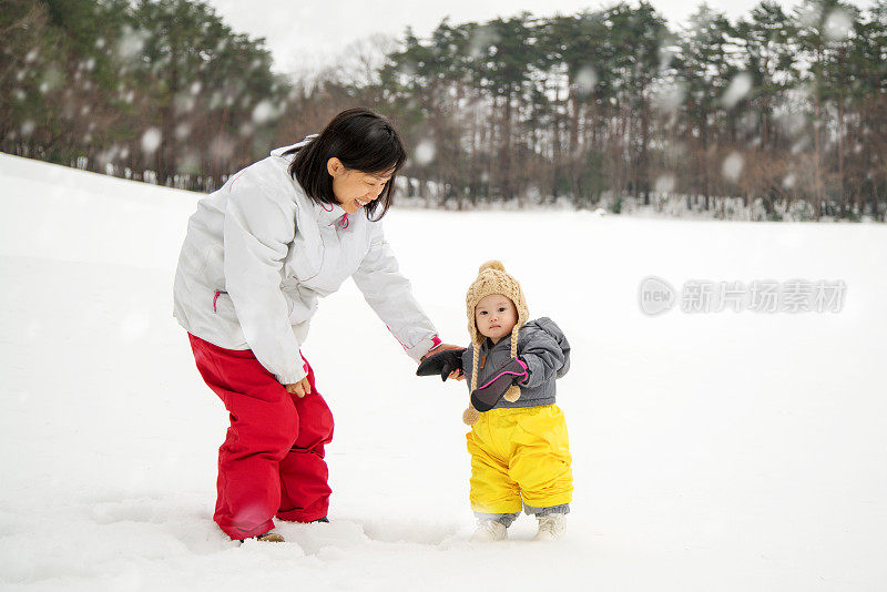 妈妈和女儿在外面玩雪