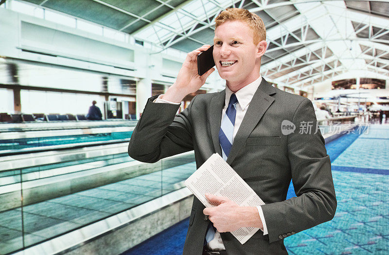 在机场对着商人微笑，用手机聊天