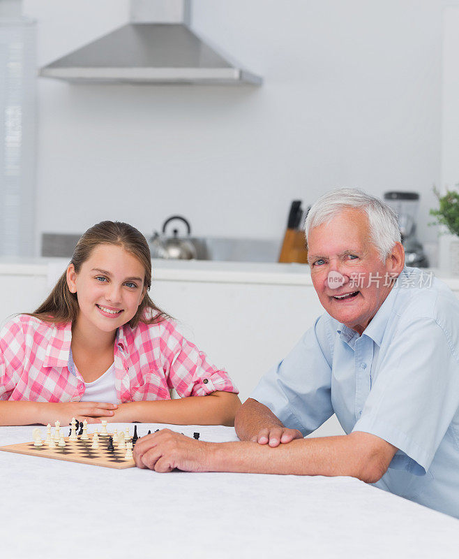 微笑的爷爷和他的孙女在下棋