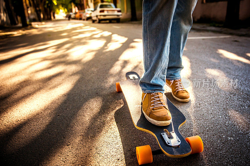 日落时分，一个男人在街上玩滑板。