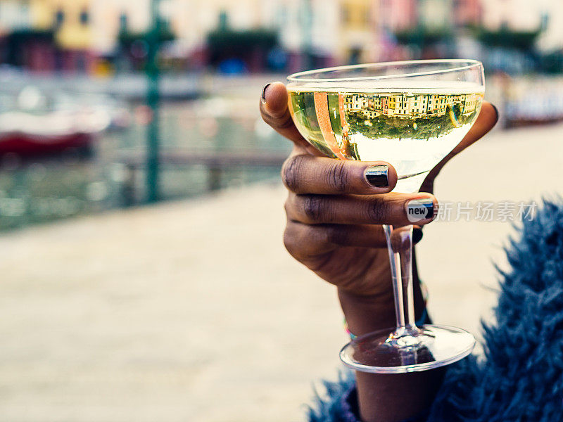 女性手捧花萼用白葡萄酒