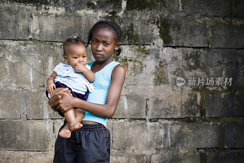 一个非洲小女孩抱着她的小妹妹