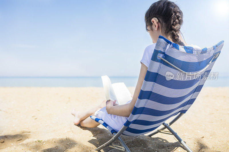 一个带着助听器的年轻女人在海滩上